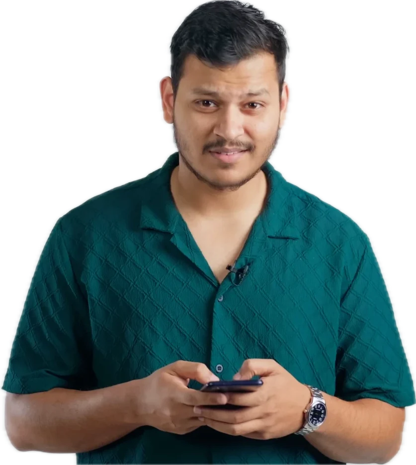 Vivek Shukla in a green shirt, smiling at the camera while typing on his phone